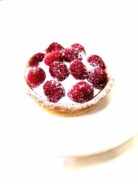 Raspberry cake tartlet on a white background on a white plate Stock Photos