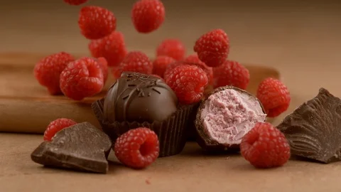 Raspberry chocolate truffle with ingredients falling in slow motion.  Shot with Stock Footage 130355169