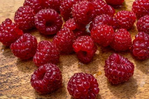 Raspberry close up macro on a wood background. Nature background. Fresh fruit. Stock Photos