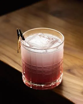 Raspberry cocktail rests on dark wood surface Stock Photos