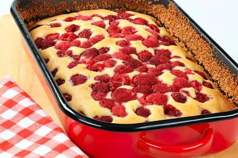 Raspberry crumble cake in red baking dish Stock Photos