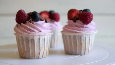 Raspberry cupcakes rotate in a circle. Yummy junk food Stock-Footage 135175990