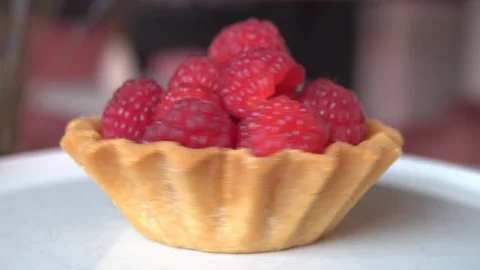Raspberry custard cake in a basket of sand dough rotates on a white plate Stock Footage 117698374