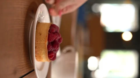 Raspberry dessert and a cup of hot fresh coffee on table in cafe in the morning Stock Footage 249339650