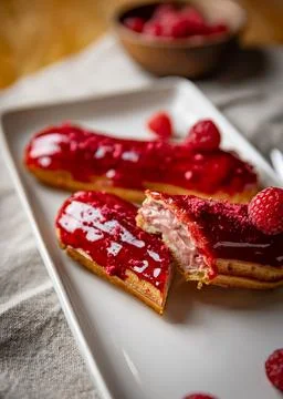 Raspberry eclairs with red raspberry icing Stock Photos