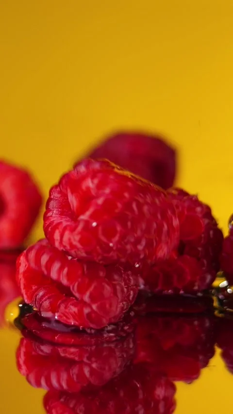 A raspberry fall on water on yellow background in slowmotion. Stock Footage 292560852