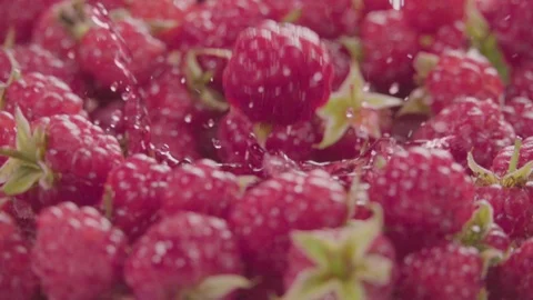 Raspberry falling in juice with splash between raspberries. Slow motion. Stock Footage 92678720