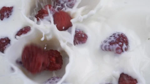 Raspberry falling into milk. Slow Motion. Stock Footage 111867421