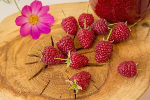 Raspberry, flower, and jam lying on an oak Board. Stock Photos