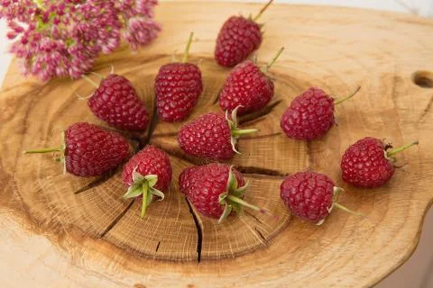 Raspberry, flower, and jam lying on an oak Board. Stock Photos