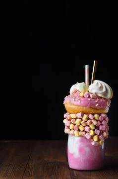 Raspberry freak shake on rustic wooden table over black background Stock Photos