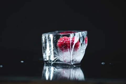 Raspberry frozen in ice cube Stock Photos