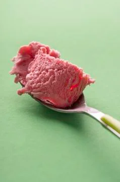 Raspberry ice cream spoon close-up. Delicious red berry dessert Stock Photos