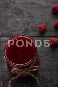 Raspberry jam and berries on a wooden table top Stock Photos