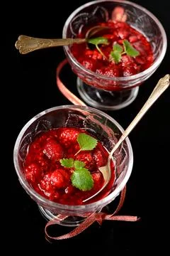 Raspberry jam in glass on black Stock Photos