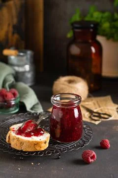 Raspberry jam in glass jar and sandwich with fresh raspberry berries on the o Stock Photos