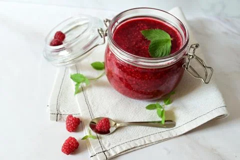 Raspberry jam in a glass jar on a white background, tea with raspberries, vit Stock Photos