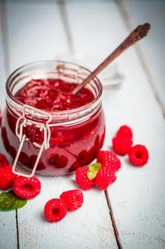 Raspberry jam in a jar on wooden background Stock Photos