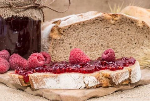 Raspberry jam on rustic background Foto stock