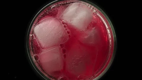 Raspberry lemonade in a glass with ice bubbles on a dark background Stock Footage 161177941