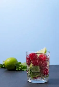 Raspberry lemonade with lime and mint in a glass. Stock Photos
