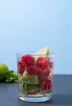 Raspberry lemonade with lime and mint in a glass. Foto stock