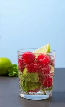 Raspberry lemonade with lime and mint in a glass. Stock Photos