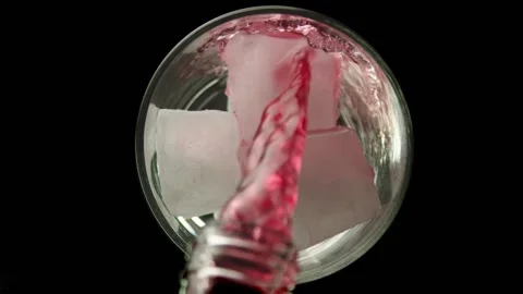Raspberry lemonade is poured into a glass with ice Stock Footage 161177352