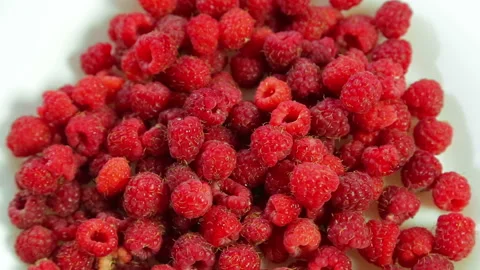 Raspberry lies on a white plate and rotates clockwise Stock Footage 92176906