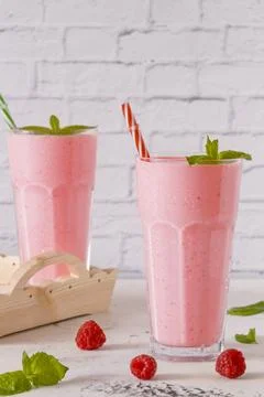 Raspberry milkshake with mint and straws. Stock Photos