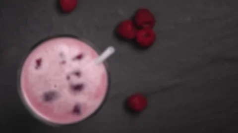 Raspberry milkshake or smoothie with scattered fresh washed organic raspberri Vídeo Stock 106359166