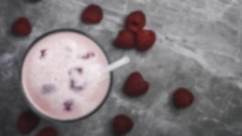 Raspberry milkshake or smoothie with scattered fresh washed organic raspberri Vídeo Stock 106359212
