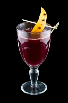 Raspberry mulled wine with orange peel. On dark background. Warming drink. Stock Photos