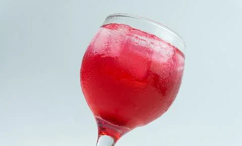Raspberry or frambozen flavored red syrup in glass cup isolated on white ba.. Stock Photos