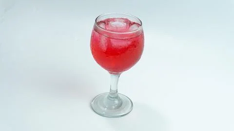 Raspberry or frambozen flavored red syrup in glass cup isolated on white ba.. Stock Photos