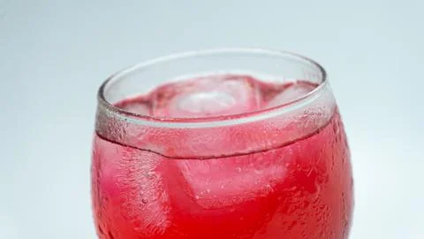 Raspberry or frambozen flavored red syrup in glass cup isolated on white ba.. Stock Photos