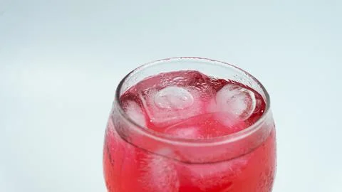 Raspberry or frambozen flavored red syrup in glass cup isolated on white ba.. Stock Photos