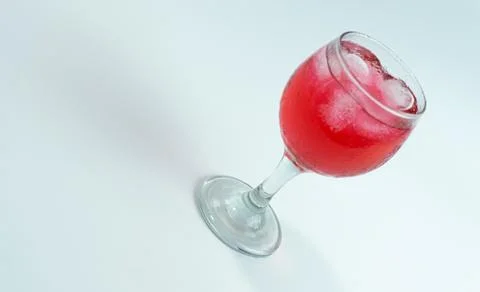 Raspberry or frambozen flavored red syrup in glass cup isolated on white ba.. Foto stock