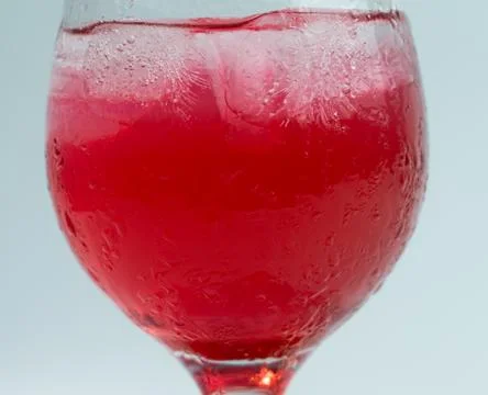 Raspberry or frambozen flavored red syrup in glass cup isolated on white ba.. Stock Photos