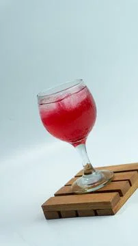 Raspberry or frambozen flavored red syrup in glass cup isolated on white ba.. Stock Photos