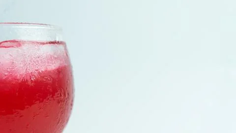 Raspberry or frambozen flavored red syrup in glass cup isolated on white ba.. Stock Photos