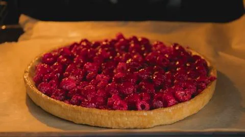 Raspberry pie on a baking sheet in the oven Stock Photos