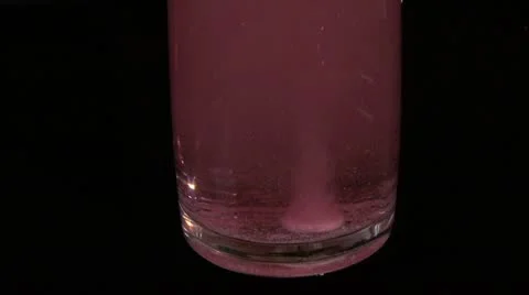 Raspberry   pill  dissolves  in  water. black background Stock Footage 10825320