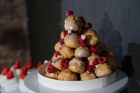 Raspberry profiteroles in the form of a slide with edible silverware Stock Photos