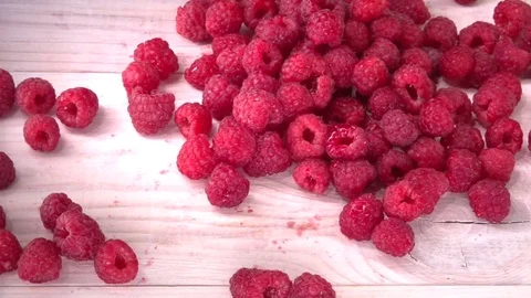 Raspberry. Raspberries falls and rolls on the white table. Video stock 81828109