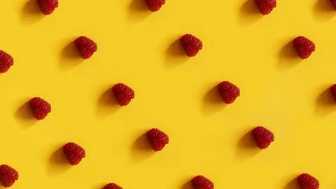 Raspberry rows on a yellow background Stock Photos
