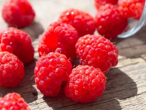 Raspberry is scattered on a wooden surface. Stock Photos
