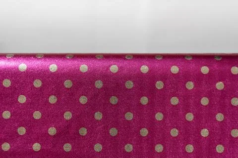 Raspberry shiny wrapping paper with polka dots with a fold. Foil for the desi Stock Photos