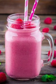 Raspberry smoothie in mason jar on rustic wooden background Stock Photos