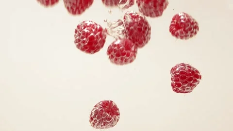 Raspberry splash falling into water, white background, aqua silver bubble drops Stock Footage 156408891